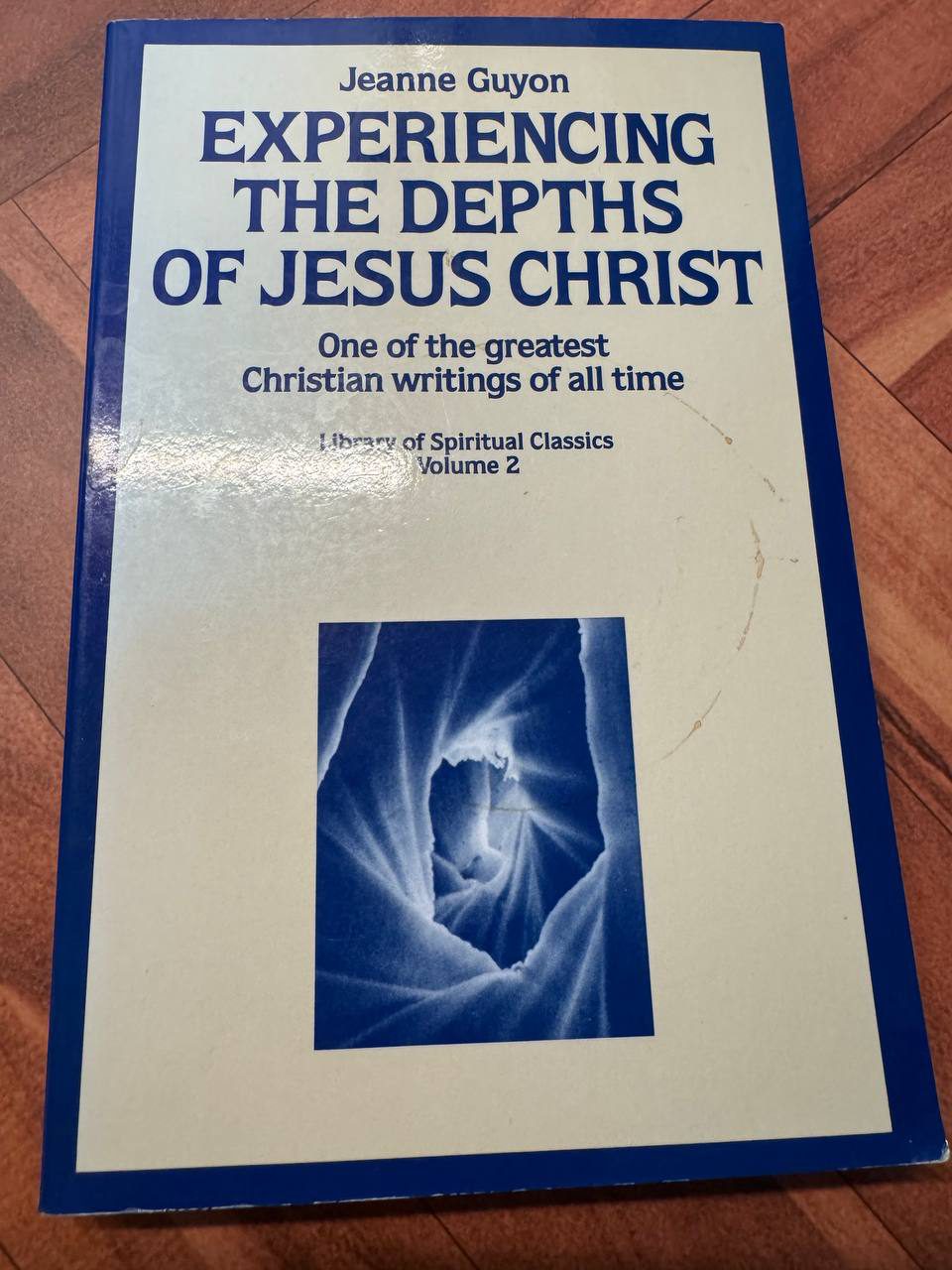 ジャンヌ・ギヨン『EXPERIENCING THE DEPTHS OF JESUS CHRIST』の表紙。濃い青の枠に白い地、中央に青い洞窟のような写真が配されている