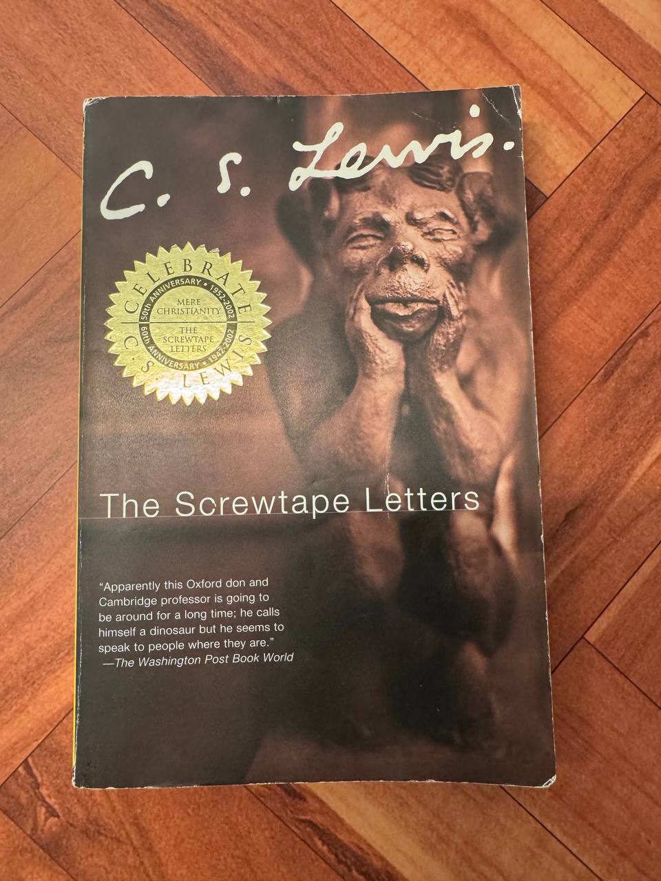 C・S・ルイス『The Screwtape Letters』のペーパーバック表紙。頬杖をついた石像のガーゴイルが暗い背景に浮かび、上部にルイスの白い署名が入っている