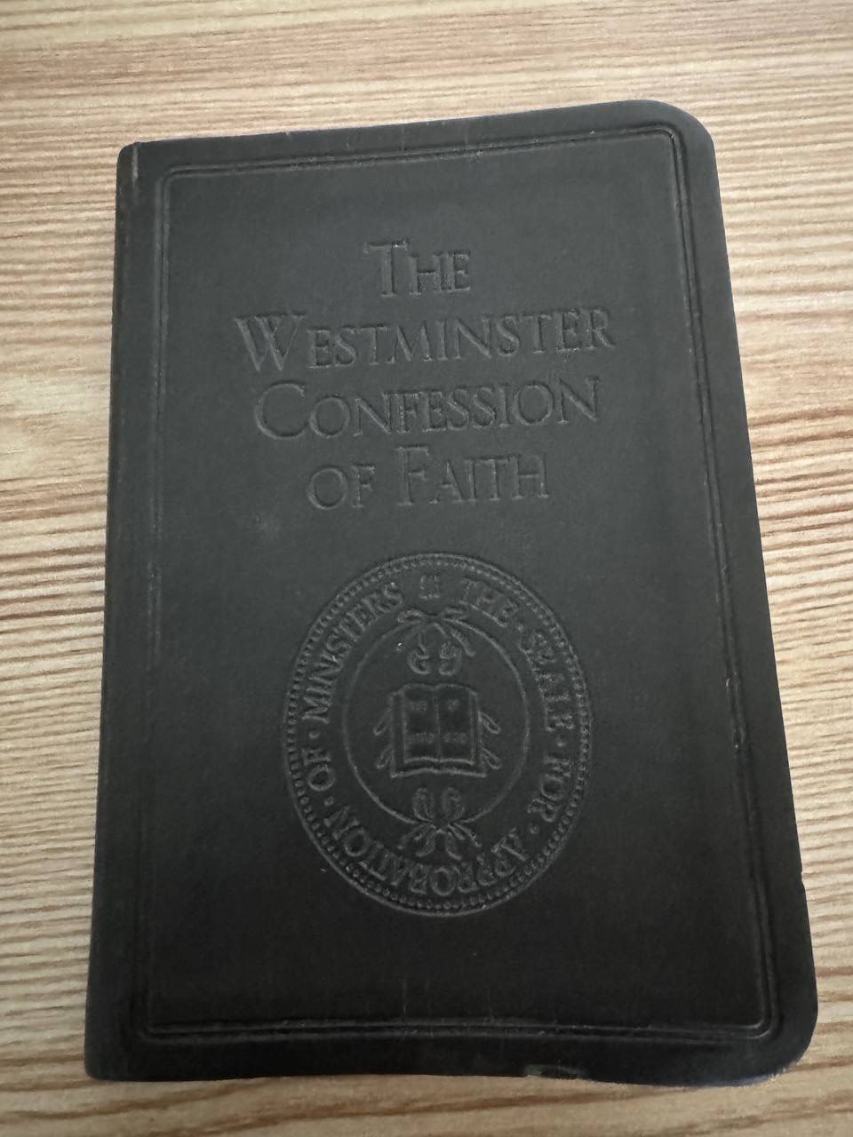 黒い革表紙に『THE WESTMINSTER CONFESSION OF FAITH』と型押しされた小さな本。開いた聖書を囲む円形の印章が下部に入っている